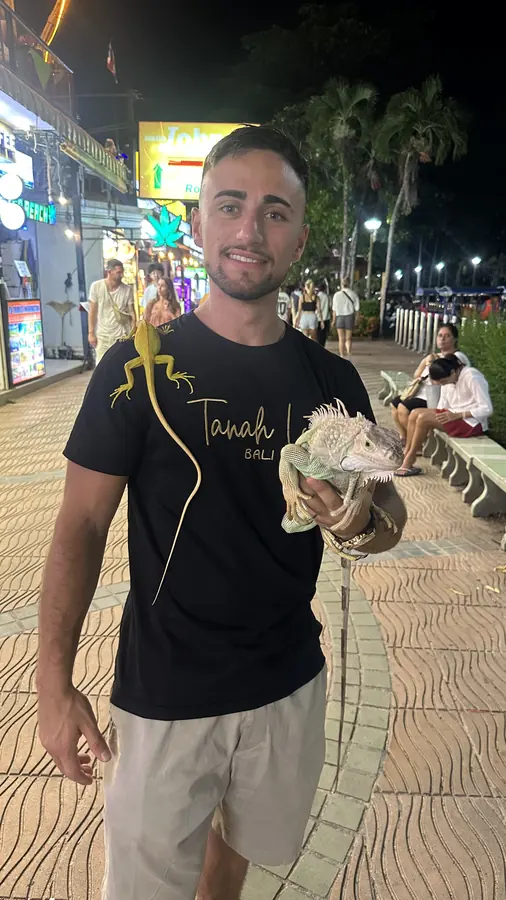 Federico holding an iguana at a night market